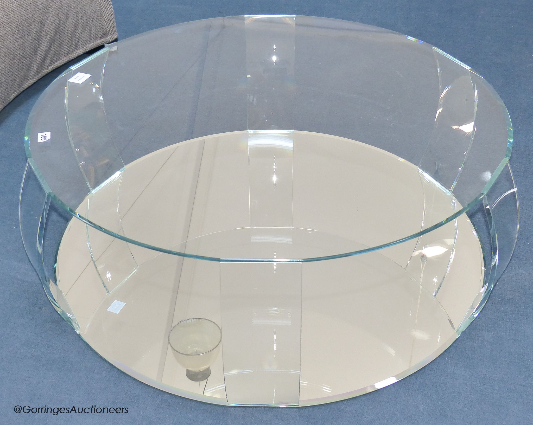 A contemporary glass circular coffee table, with mirrored base, 98 cm wide, 33 cm high